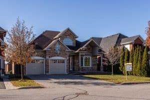 a home with a for sale sign real estate roofing