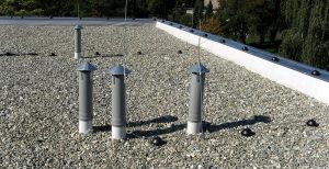 Photo of commercial flat roofing system with rocks on roof