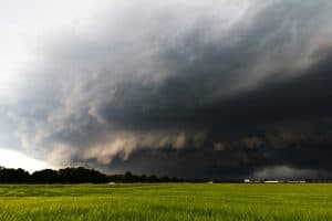 Dark cloud that could produce hail storms passes over a grassy field