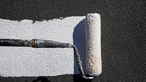 An image of a paint roller with GACO roof coating in Denver