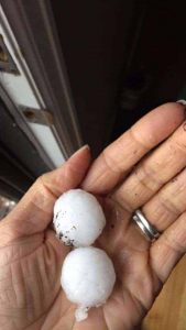 Two large hail stones in a hand from a hail storm in Lakewood.